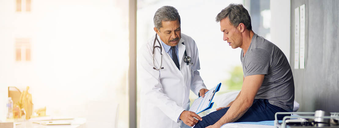 Shot of a mature doctor examining his patient who is concerned about his knee